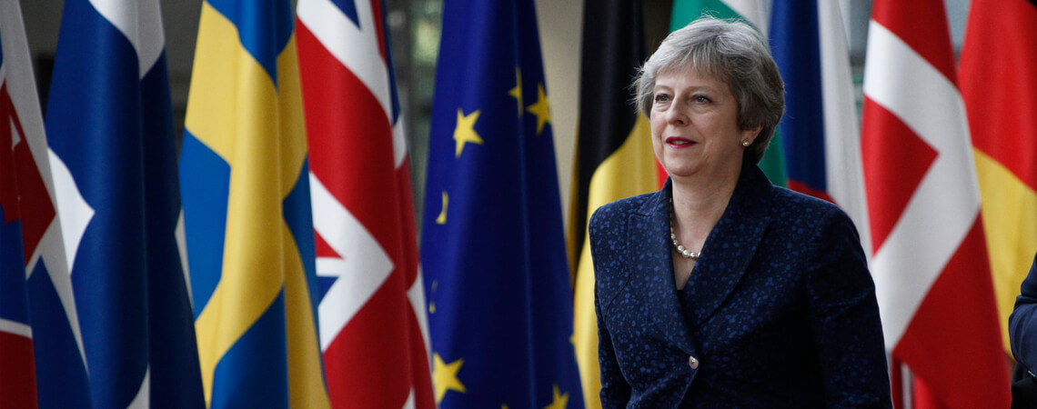 Theresa May vor europäischen Flaggen