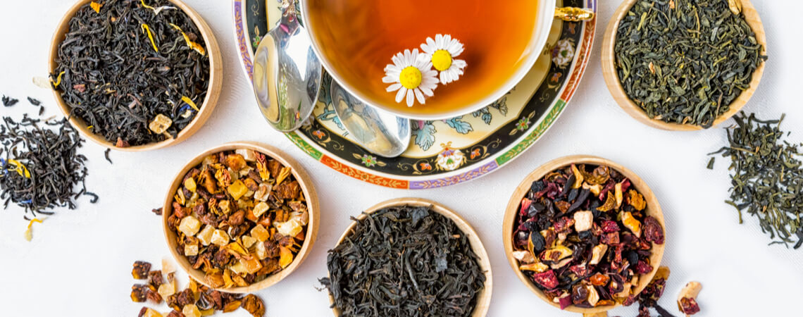 Teetasse mit verschiedenen Kräutern ringsherum
