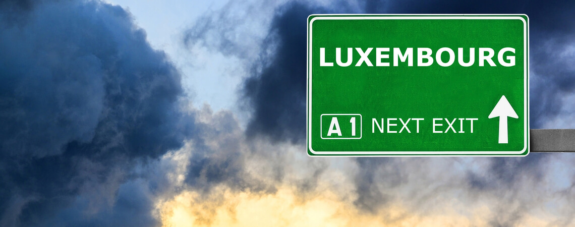 Straßenschild Luxemburg vor Wolken