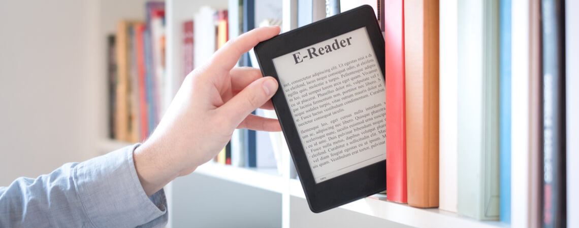 E-Book-Reader wird aus Bücherregal genommen.