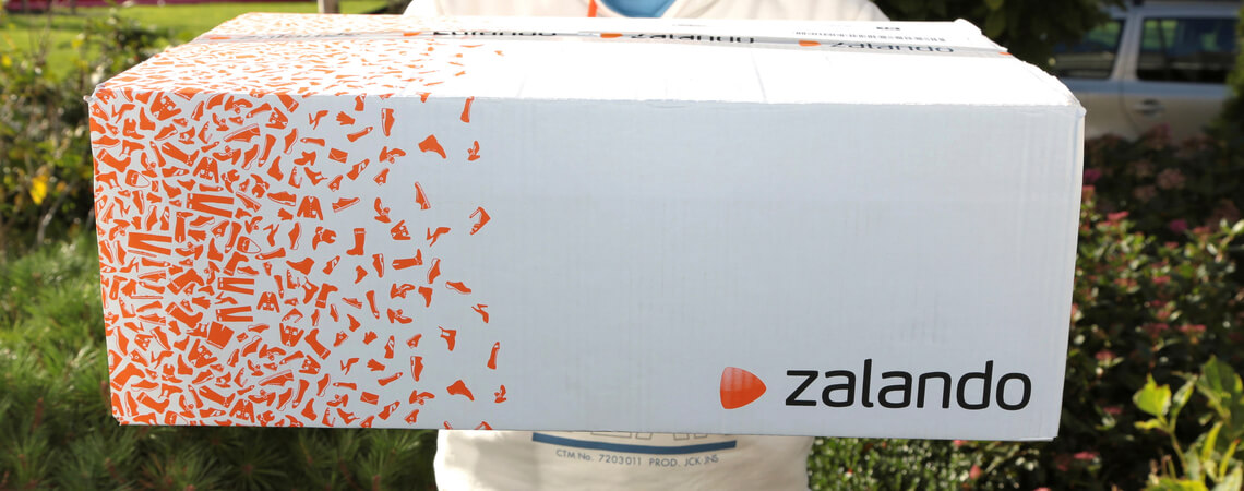 Paketbote mit Zalando-Paket in den Händen
