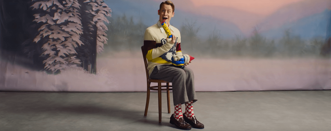 Macaulay Culkin mit bunten Socken und Spielzeug