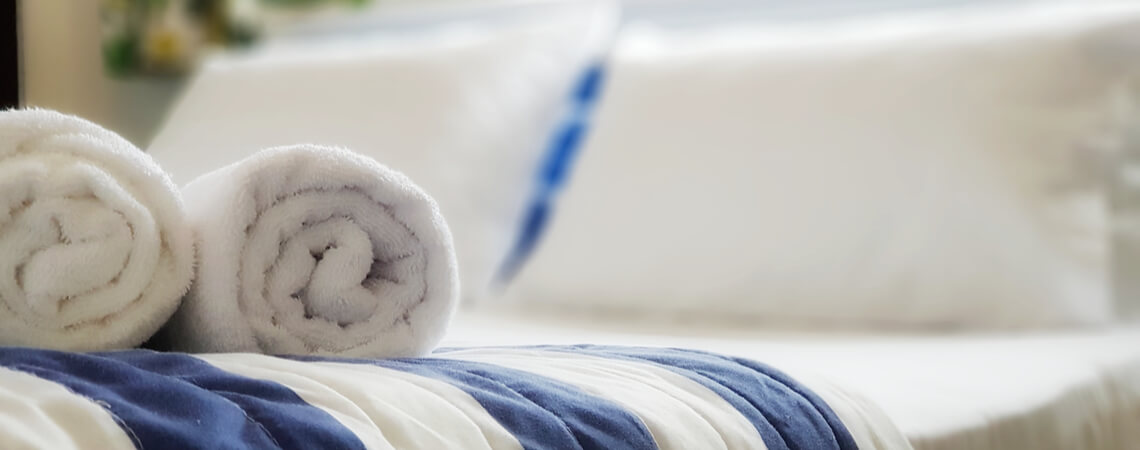 Gerollte Handtücher auf Bett