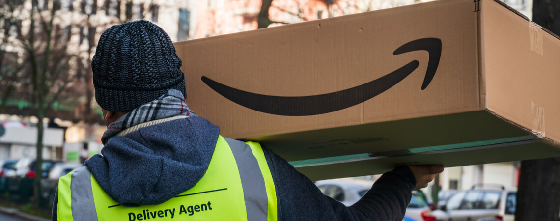 Zusteller trägt Amazon-Paket
