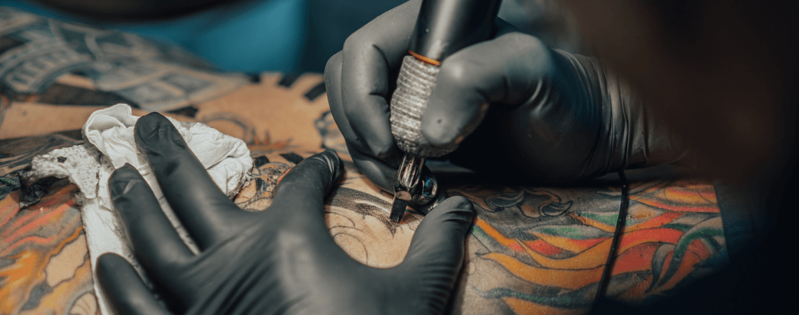 Tätowierer sticht ein Tattoo