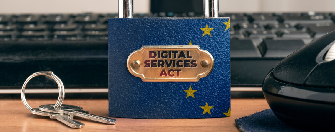 Vorhängeschloss mit Aufschrift "Digital Services Act" vor Computer