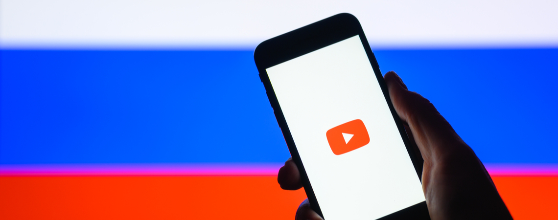 YouTube auf Smartphone vor Russland-Flagge
