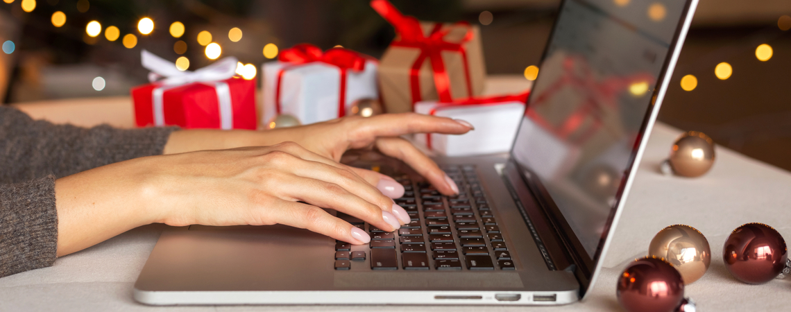 Person am Laptop Online-Shopping zu Weihnachten