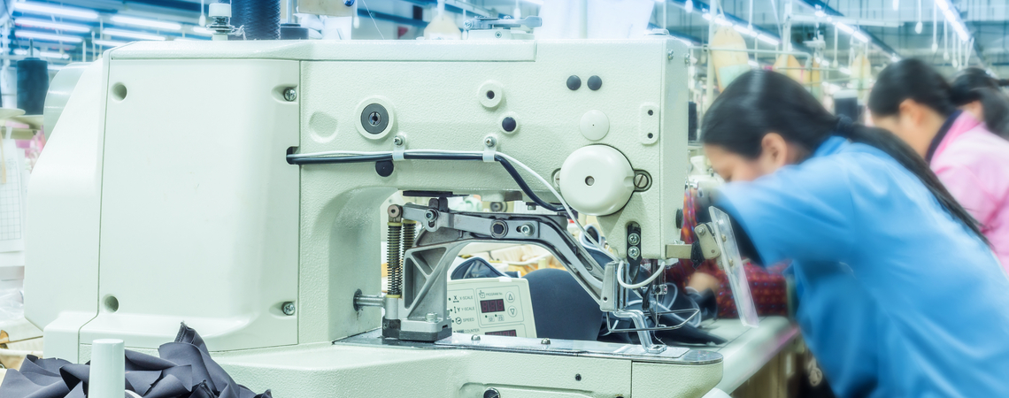 Arbeitskräfte und Nähmaschine in Textilfabrik