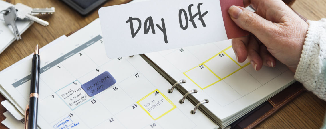 Person vor Kalender hält Schild Day off