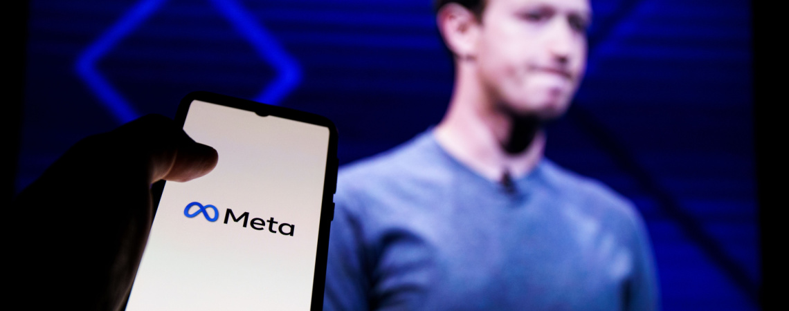 Smartphone mit Meta-Logo neben Mark Zuckerberg