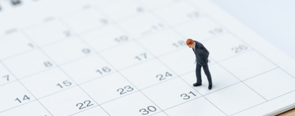 Miniatur von einem Geschäftsmann steht auf einem Kalender