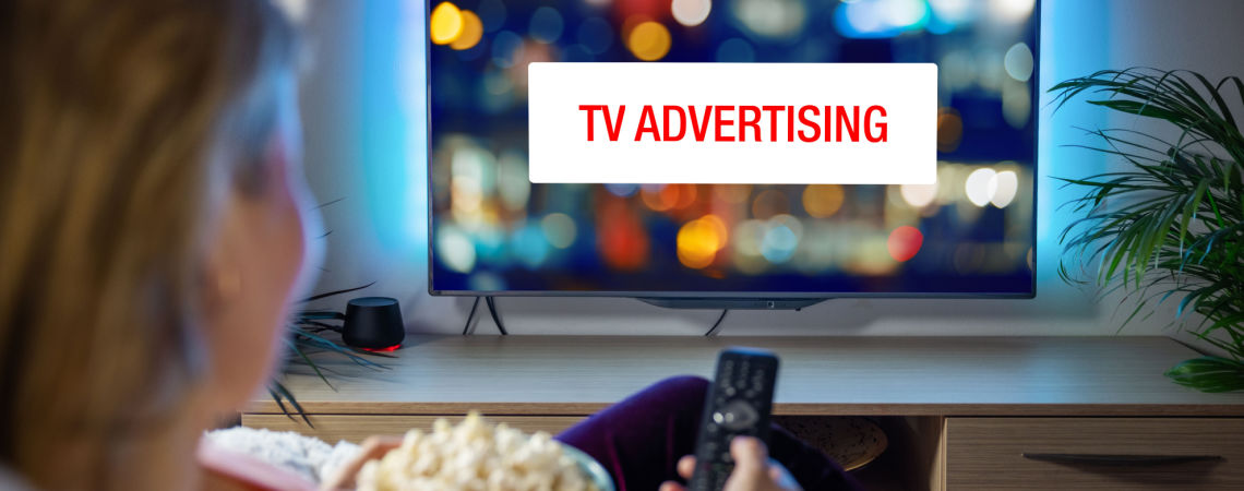 Frau sieht Werbung im TV