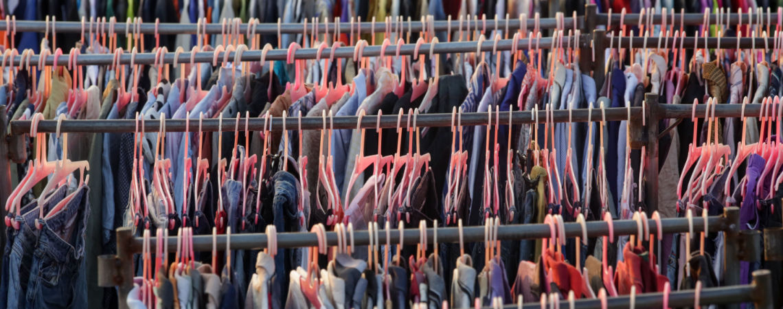 Sehr viele Kleidungsstücke hängen an Kleiderstangen