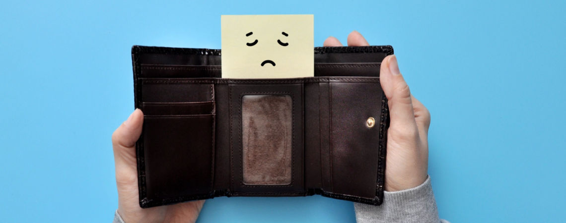 Mann mit offenem Portemonnaie und anstatt Geld - ein trauriges Gesicht.
