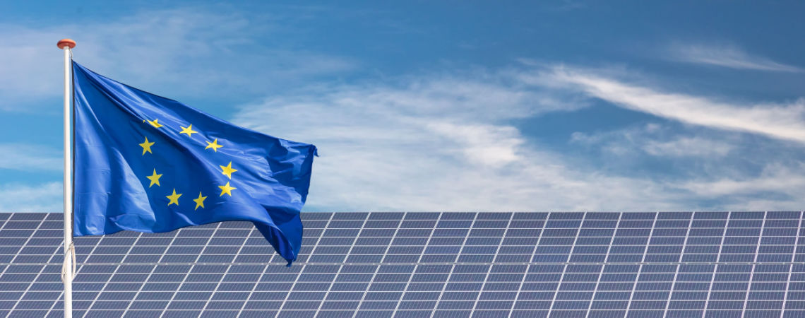 EU-Flagge vor Sonnenkollektoren