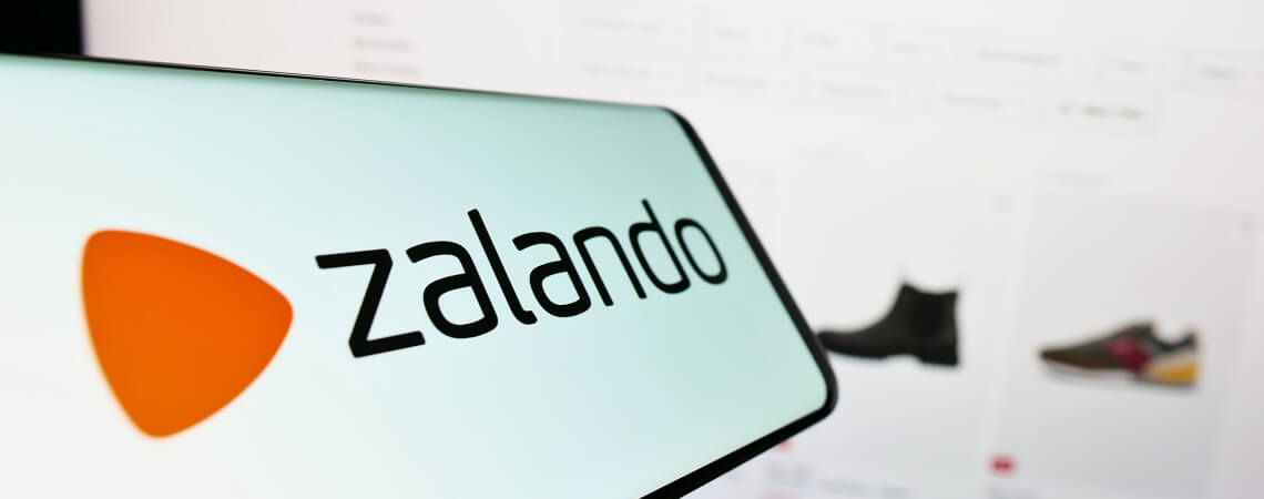 Zalando-Logo auf Smartphone und Webseite im Hintergrund