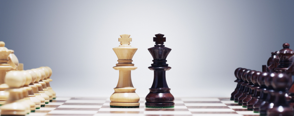 Weißer und schwarzer König auf Schachbrett nebeneinander.
