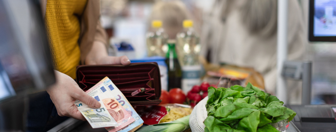 Frau bezahlt mit Euroscheinen an Supermarktkasse