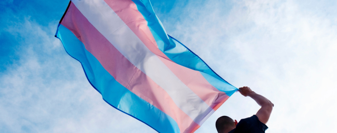 Perso hält Flagge für Trans