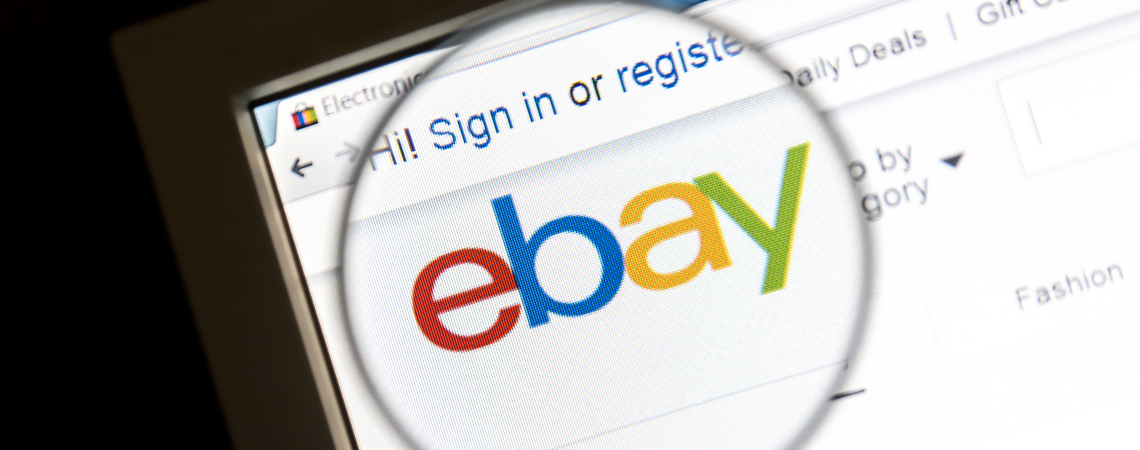 Ebay auf Bildschirm hinter einer Lupe