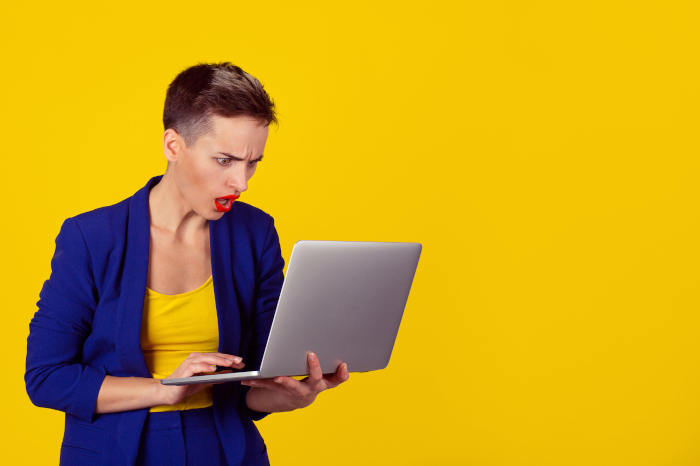 Wütende Frau starrt auf Laptop