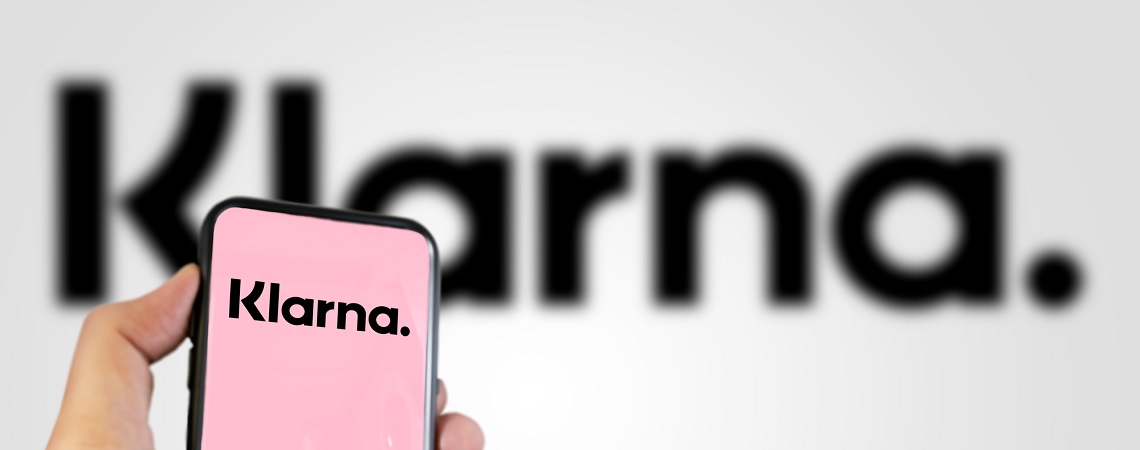 Klarna-Logo auf Smartphone und im Hintergrund