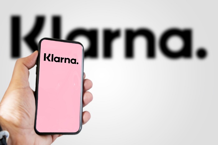 Klarna-Logo auf Smartphone und im Hintergrund