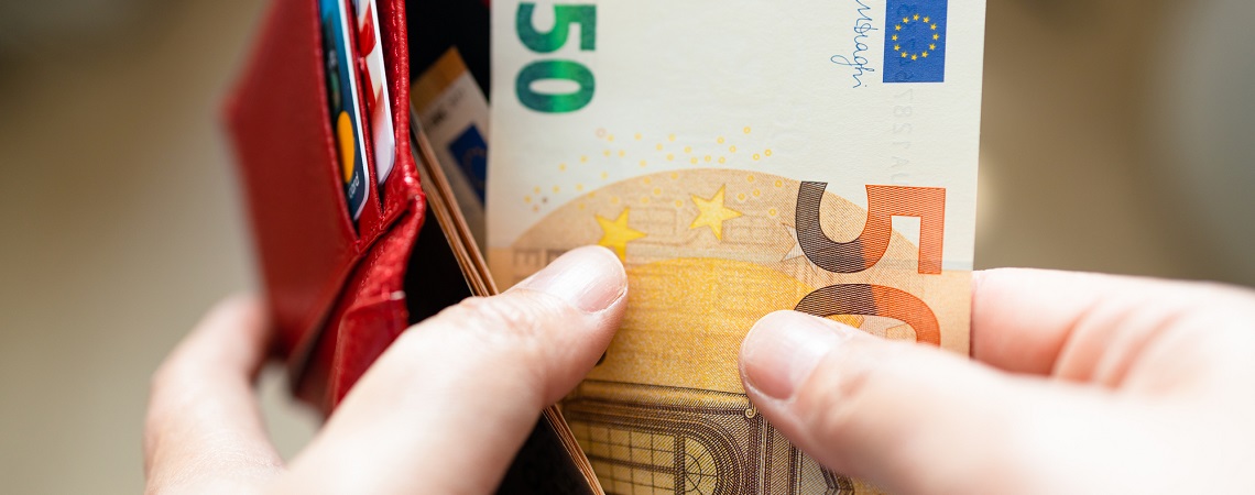 Person nimmt 50 Euro aus dem Portemonnaie