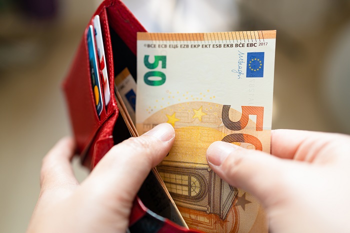 Person nimmt 50 Euro aus dem Portemonnaie