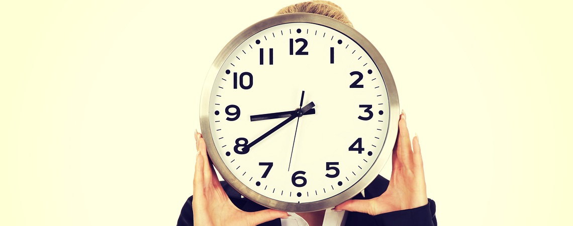 Arbeitszeit: Frau hält sich Uhr vor das Gesicht