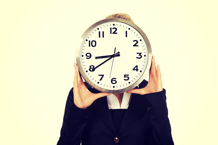 Arbeitszeit: Frau hält sich Uhr vor das Gesicht